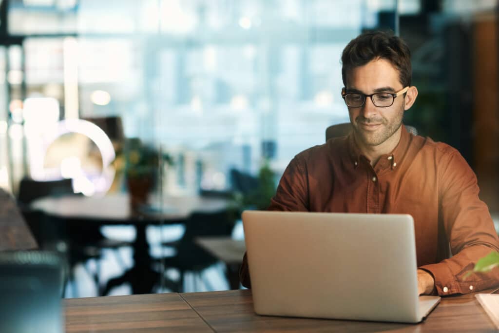 Man in a beige button up shirt woking on SEO optimising his blog post.